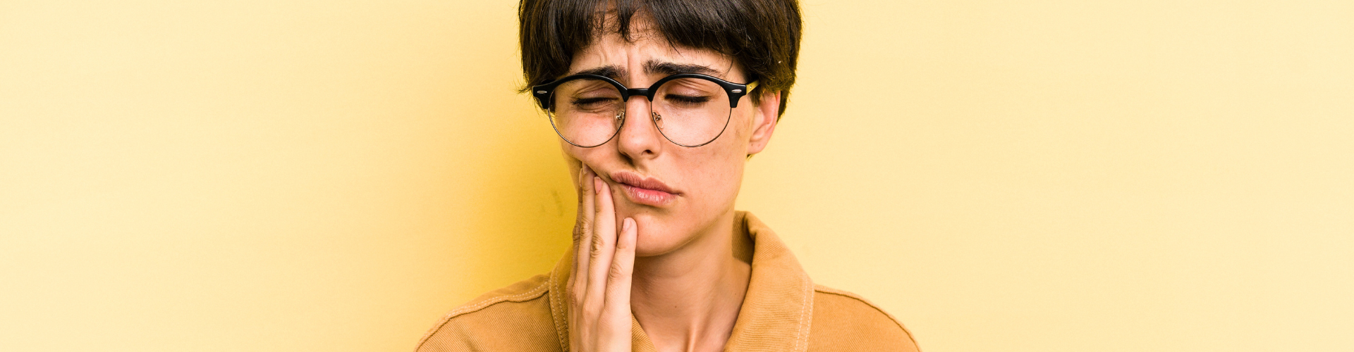 Woman holding her jaw in pain.